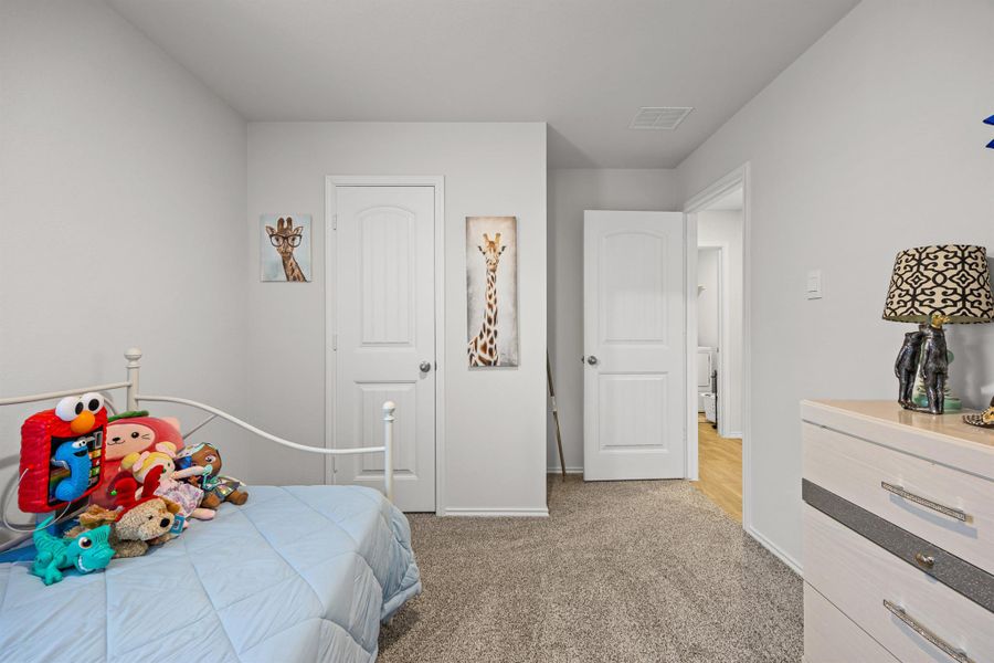 Bedroom with light colored carpet and baseboards