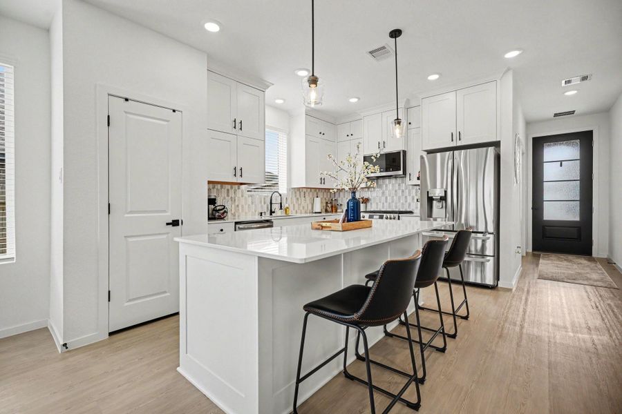 Spacious kitchen featuring stainless steel appliances, designer backsplash, and an oversized island perfect for gatherings. Spacious kitchen featuring stainless steel appliances, designer backsplash, and an oversized island perfect for gatherings.