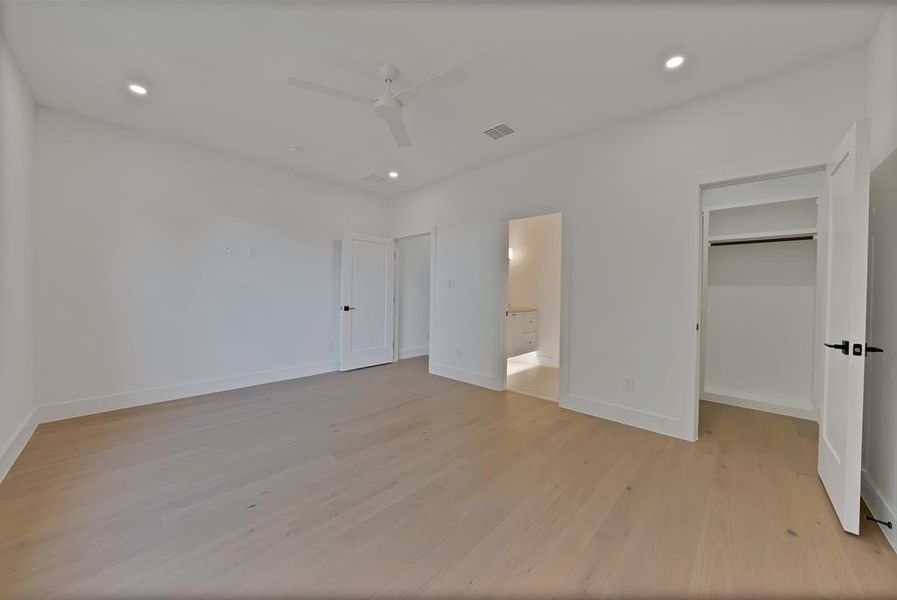 Spacious room featuring light wood-finish flooring, recessed lighting, and a ceiling fan