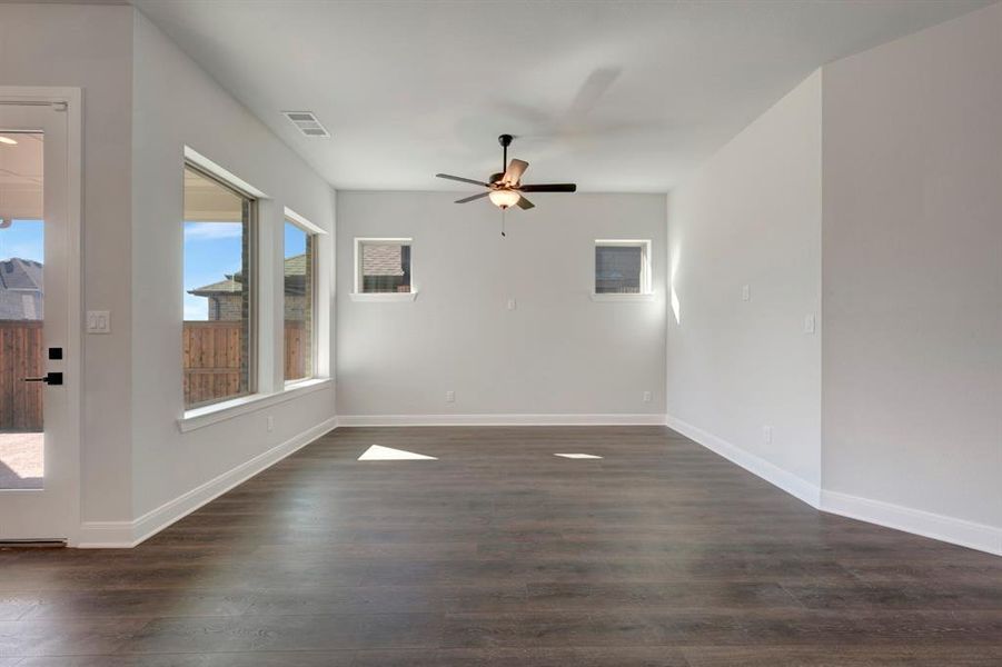 Empty room featuring ceiling fan and dark wood-style flooring