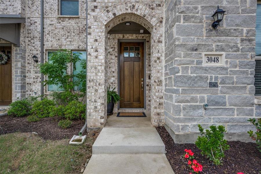 Arched brick porch frames the front door, creating an impressive front entry way.
