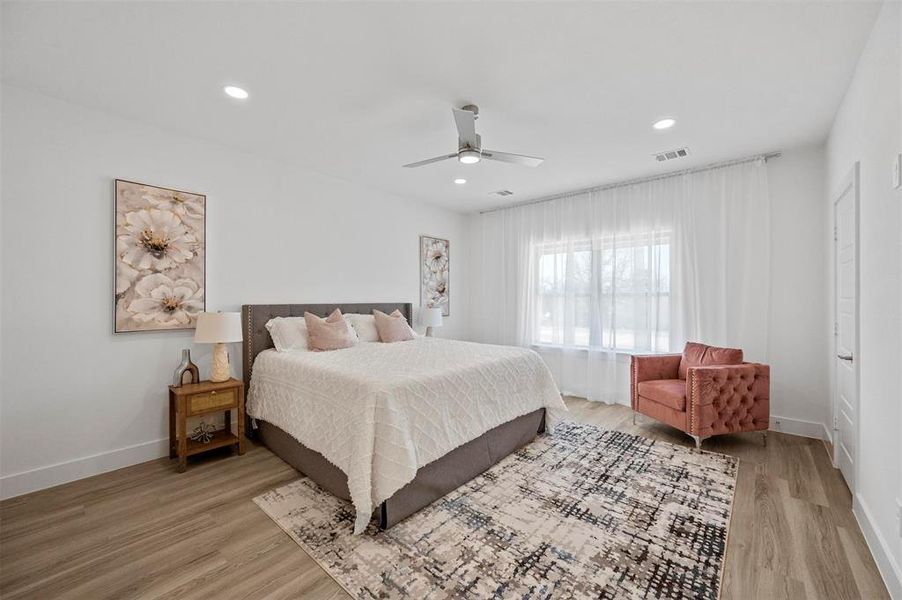 Bedroom with light wood-style floors, baseboards, visible vents, and recessed lighting