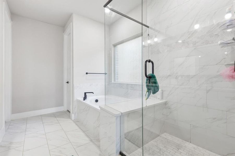 Bathroom with a garden tub, a marble finish shower, and light marble finish floors