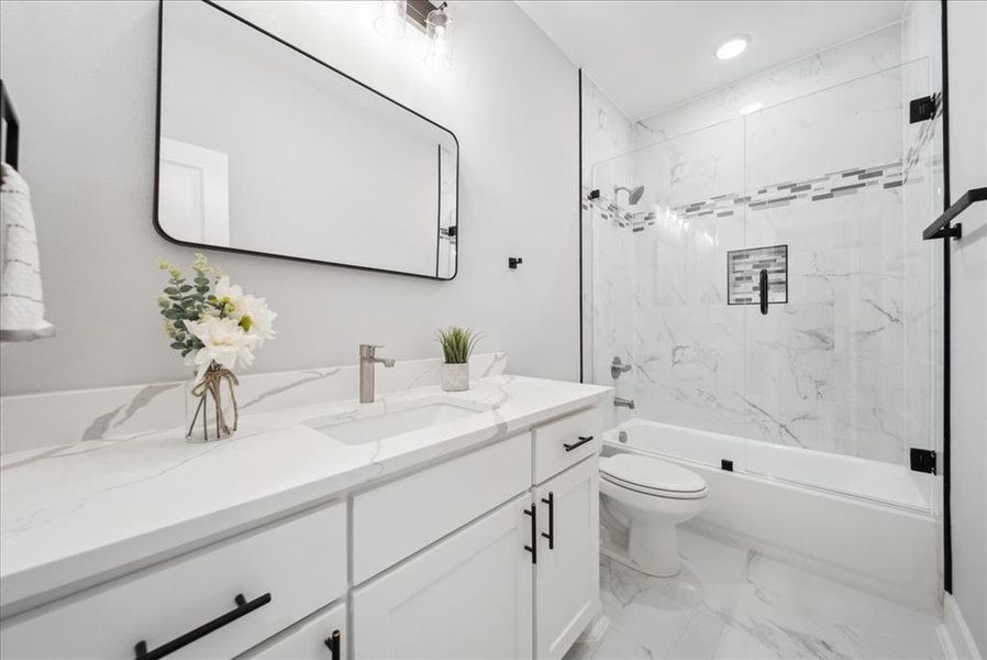 Full bathroom featuring bath / shower combo with glass door, toilet, and vanity