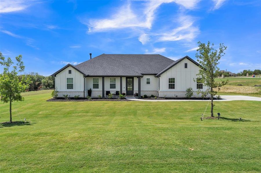 White siding exterior with a dark gray shingle roof and a concrete driveway