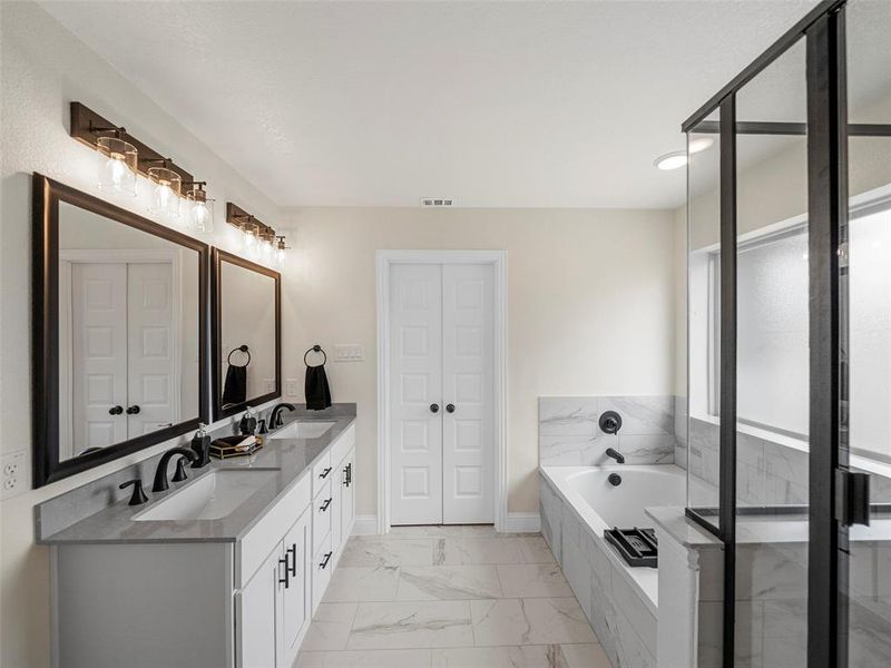 Bathroom with vanity and tiled bath