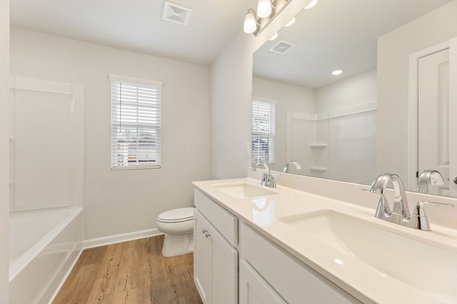 A bathroom with a tub sink and toilet.