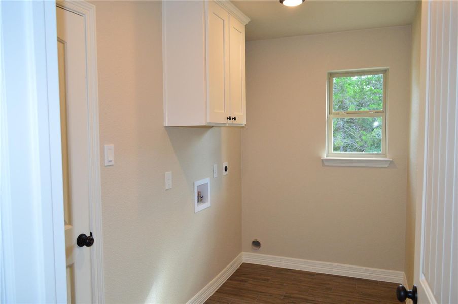 Laundry room featuring hookup for an electric dryer, cabinet space, dark wood finished floors, and washer hookup