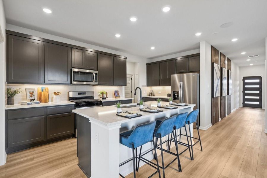 A well-appointed kitchen features stainless steel appliances, a generous island with seating, and bright recessed lighting. A well-appointed kitchen features stainless steel appliances, a generous island with seating, and bright recessed lighting.