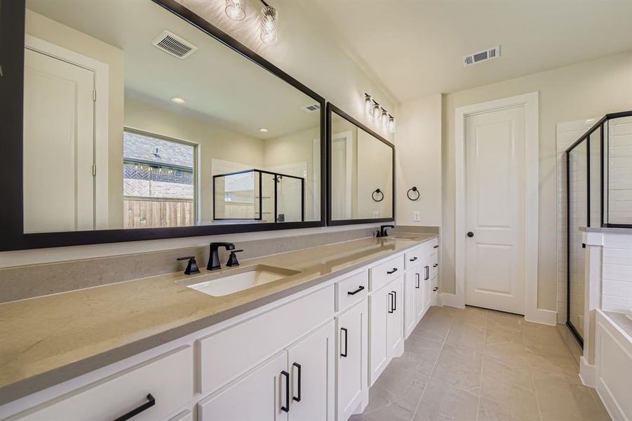 Bathroom featuring a shower stall, double vanity, light tile patterned floors, and recessed lighting
