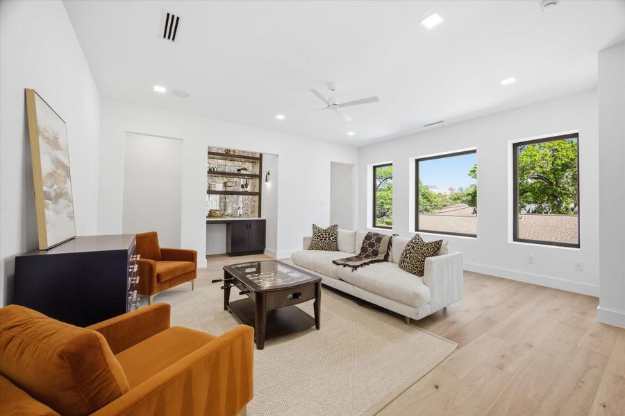 A spacious upstairs living area offers the perfect balance of comfort and versatility, ideal for a secondary lounge, media room, or game space.