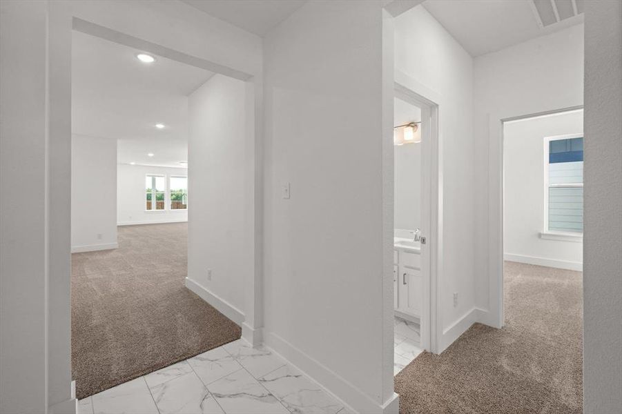 Hallway featuring tile and  carpet