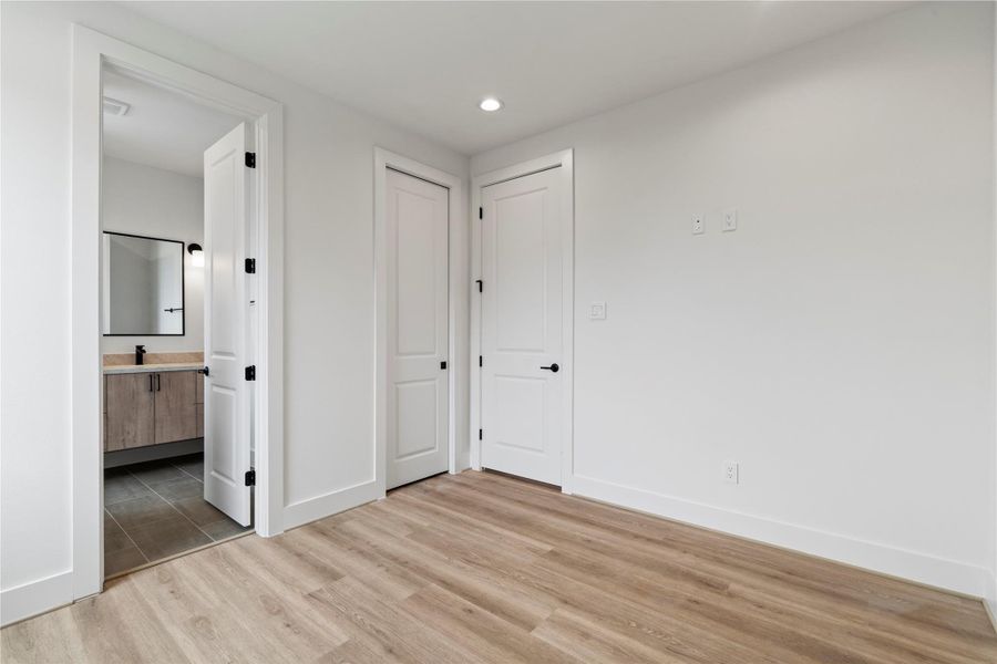 This guest bedroom includes a walk-in closet and private ensuite bath, complete with modern sconce lighting. This guest bedroom includes a walk-in closet and private ensuite bath, complete with modern sconce lighting.