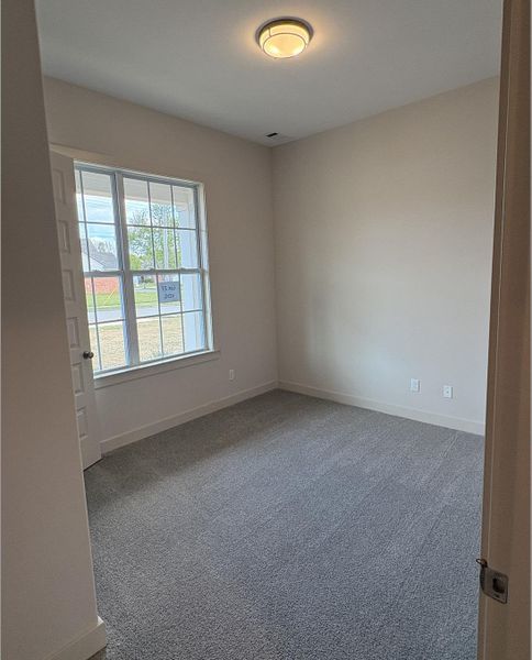 Spare room featuring baseboards and carpet