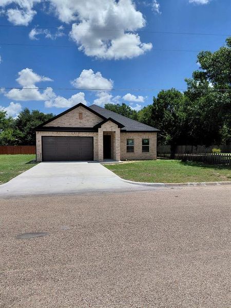 View of front of house featuring concrete driveway, a garage, and brick siding