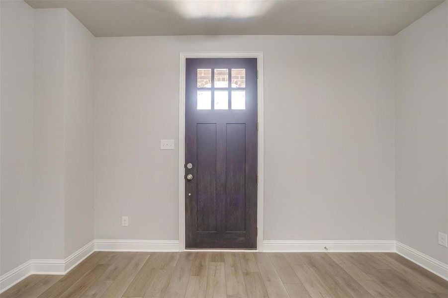 Entryway featuring light wood-style floors and baseboards Entryway featuring light wood-style floors and baseboards