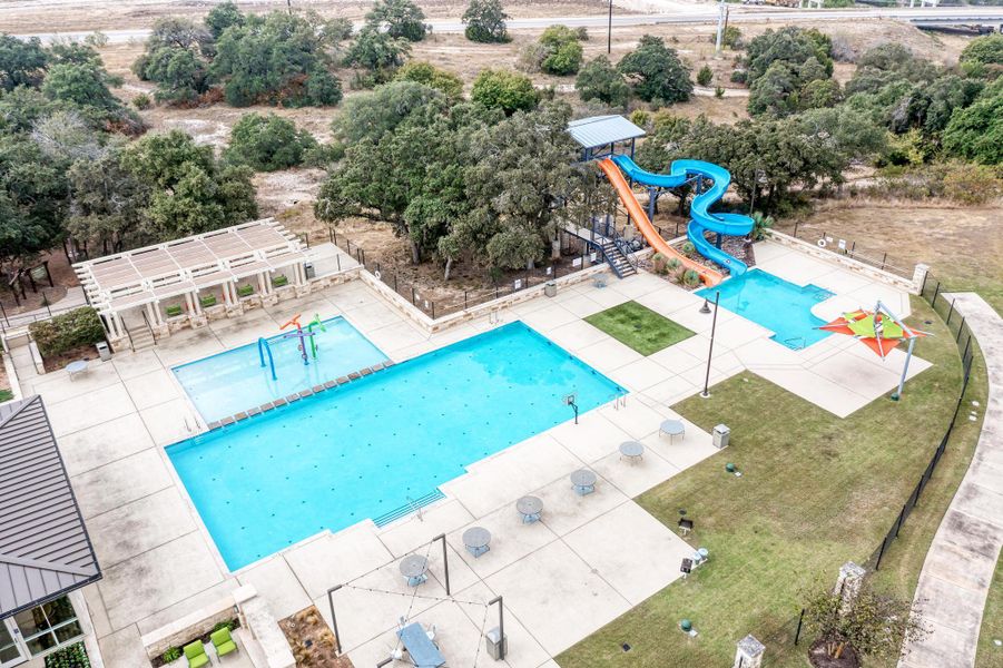 Community pool with a water slide and a patio area