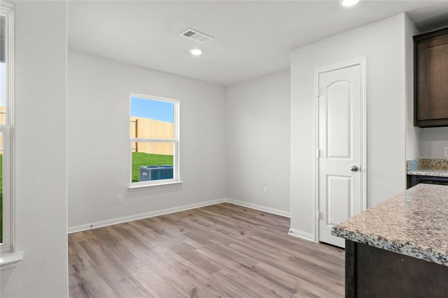 Unfurnished dining area with light wood-type flooring, recessed lighting, and baseboards