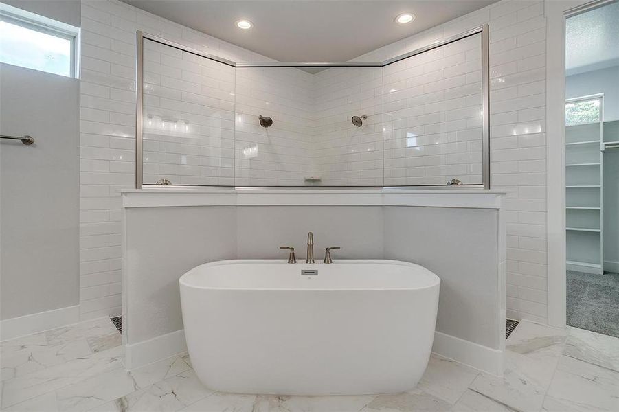 Bathroom with tiled shower and tile patterned floors