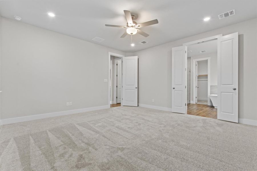 Unfurnished bedroom featuring ceiling fan and light carpet