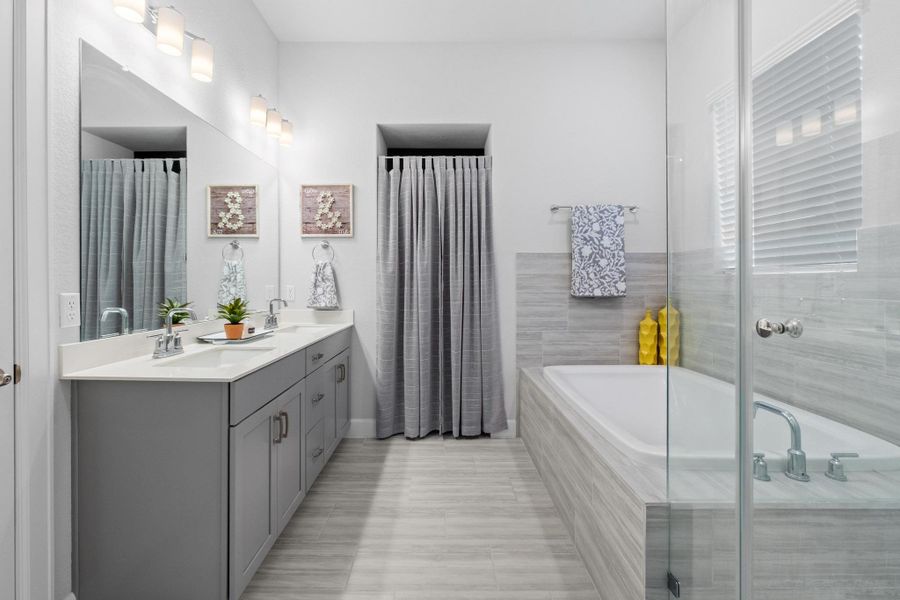 Full bathroom with double vanity, baseboards, a sink, and a garden tub Full bathroom with double vanity, baseboards, a sink, and a garden tub