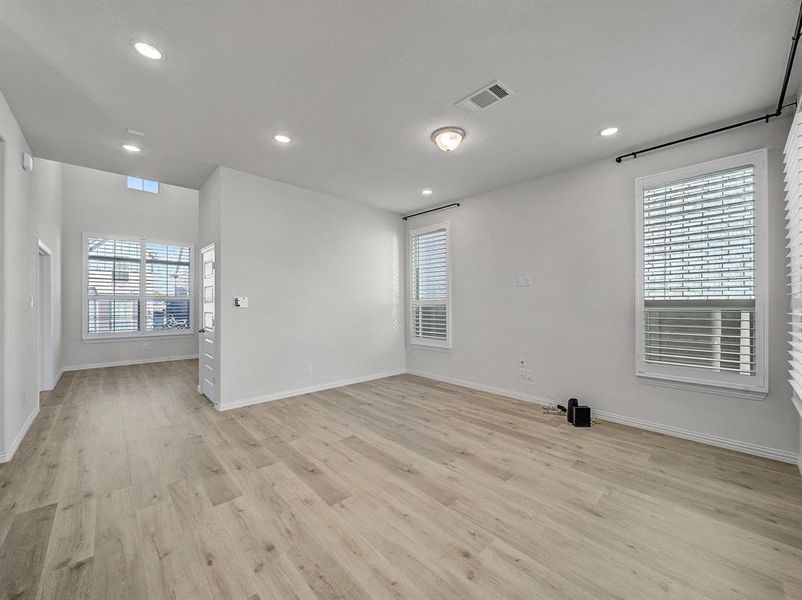 Unfurnished room with a healthy amount of sunlight and light hardwood / wood-style floors