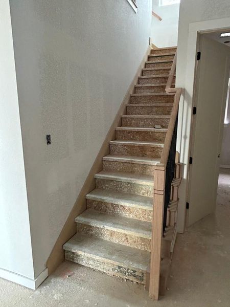 Stairs featuring a textured wall