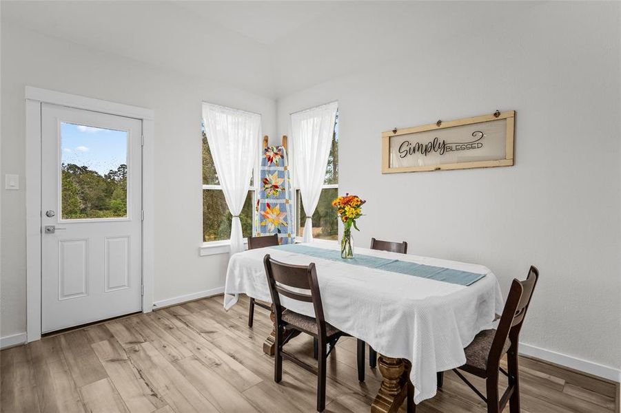 The dining area is bright featuring large windows with nature and lake views.