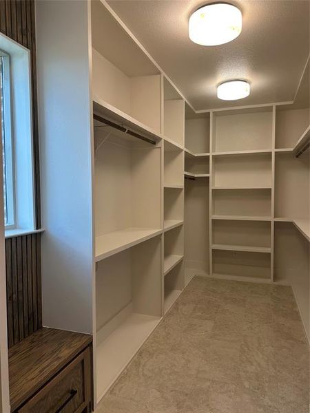 Custom built-in white shelving system with hanging rods and varied storage cubbies