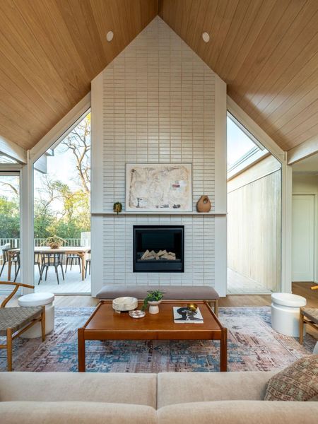 Living area with a high wood ceiling, wood finished floors, a fireplace, and healthy amount of natural light