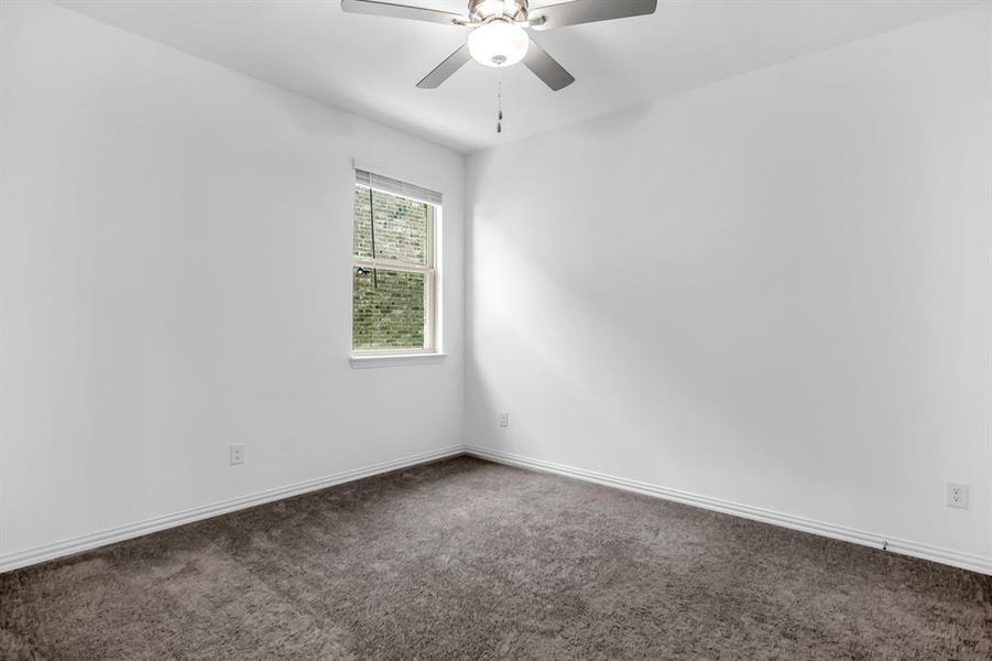 Room featuring a single window with blinds, a ceiling fan with integrated lighting, white walls, and dark gray carpeting