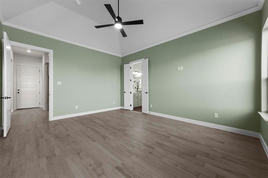 Unfurnished bedroom with ceiling fan, light hardwood / wood-style flooring, crown molding, and lofted ceiling