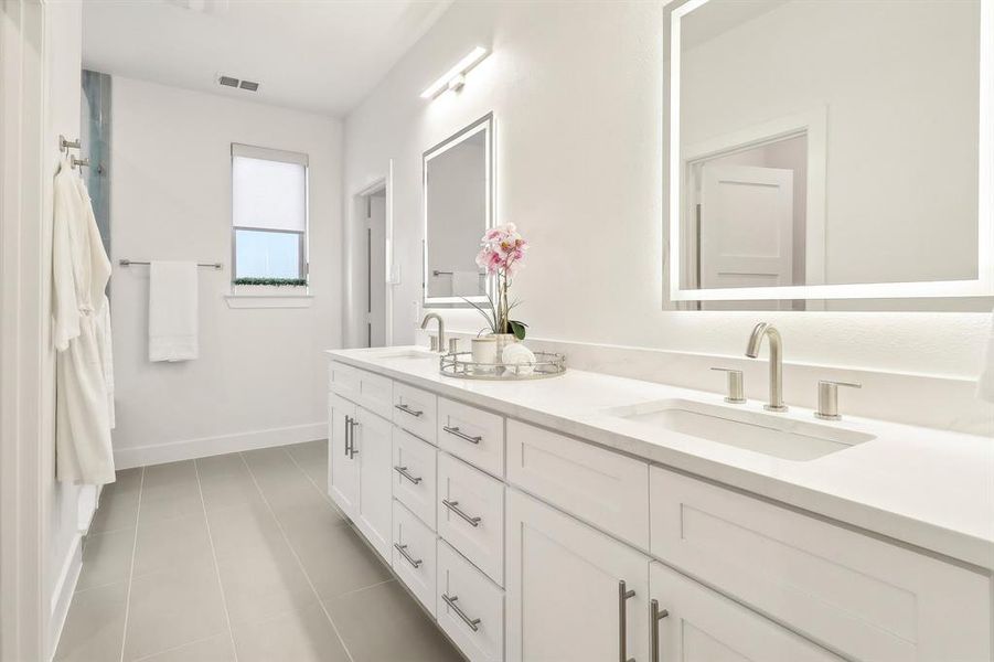 Bathroom featuring tile patterned flooring, visible vents, a sink, and baseboards