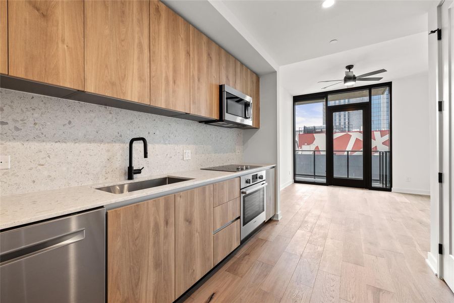 Entry into the residence, with a galley kitchen to your left and opens into the living room. This photograph depicts the floor plan. These photos are a depiction of the Desert Calm finish. Unit 1508 has the Industrial Rainey finish out.