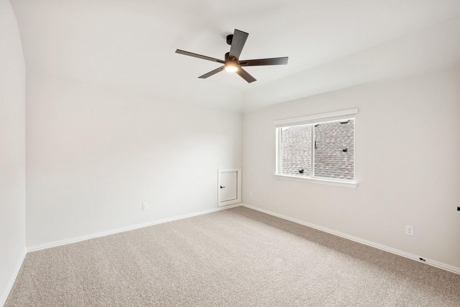 Empty bedroom with beige carpet, ceiling fan, and single window with white walls Empty bedroom with beige carpet, ceiling fan, and single window with white walls