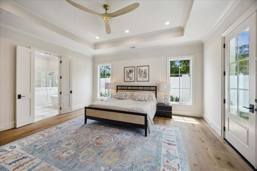 From this perspective, the primary suite’s thoughtful layout continues with symmetrical windows framing the headboard and enhancing the light-filled ambiance. A seamless transition leads into the spa-inspired primary bath, while the beautiful finishes and airy scale complete this luxurious, private retreat.
