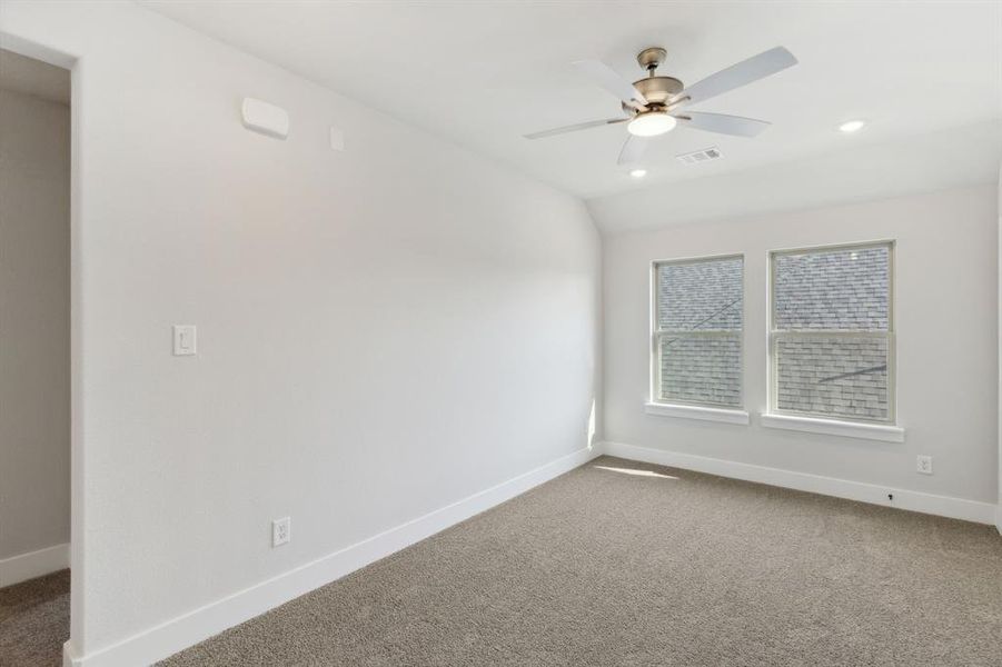 Carpeted empty room with ceiling fan