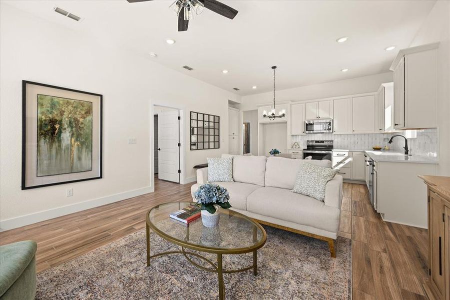 Open-concept living area featuring wood-finish flooring, recessed lighting, and a ceiling fan
