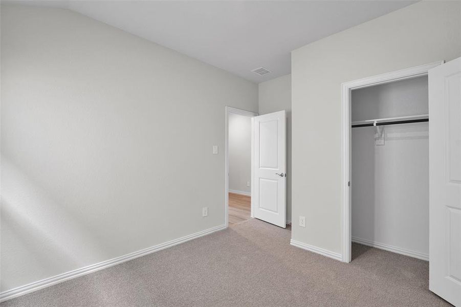 Unfurnished bedroom featuring light colored carpet and a closet Unfurnished bedroom featuring light colored carpet and a closet