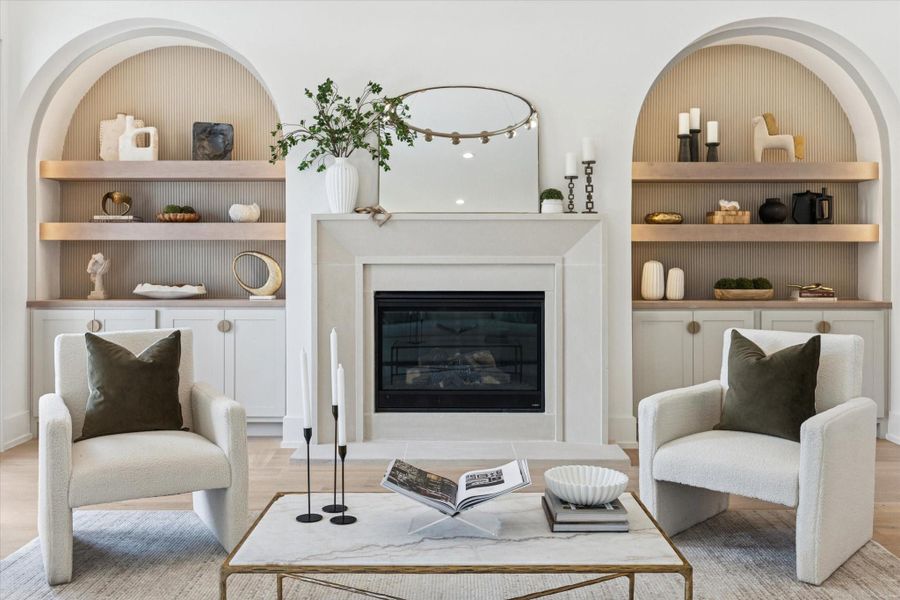 Gorgeous living room anchored by a cast stone surround fireplace, flanked by two arched built-ins with integrated lighting.