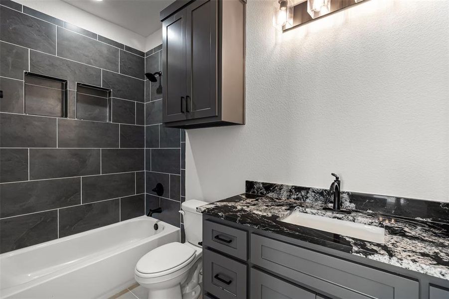 Full bathroom with vanity, toilet, and tiled shower / bath