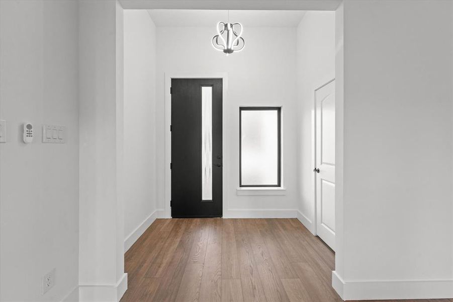 Entryway with light hardwood / wood-style flooring and an inviting chandelier