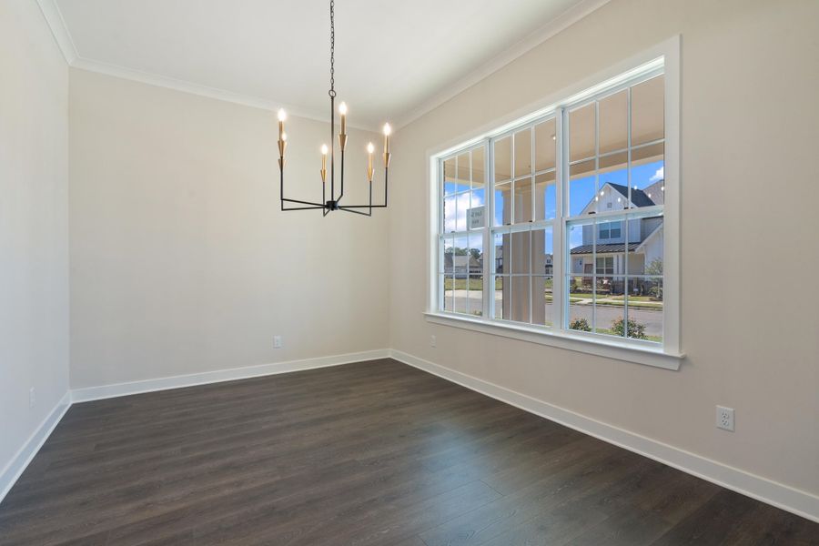 Unfurnished dining area with a chandelier, dark wood-style floors, and crown molding Unfurnished dining area with a chandelier, dark wood-style floors, and crown molding