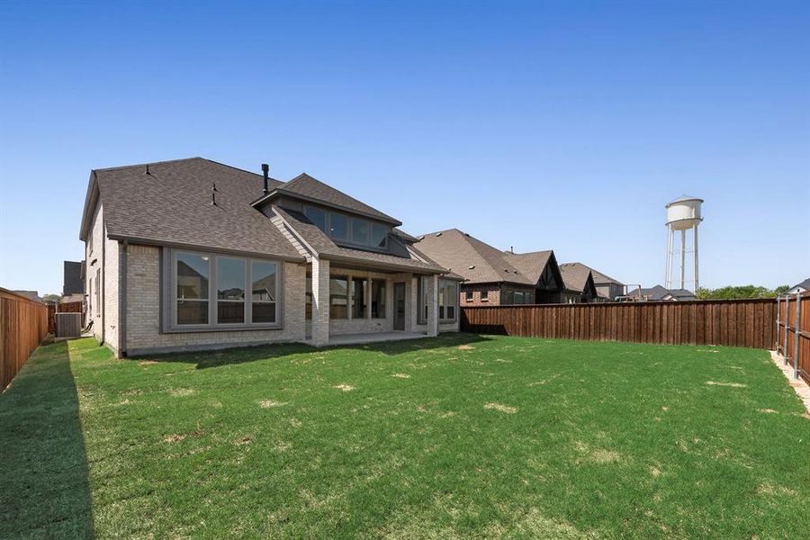 Rear view of house featuring a fenced backyard, a shingled roof, a patio, and brick siding Rear view of house featuring a fenced backyard, a shingled roof, a patio, and brick siding