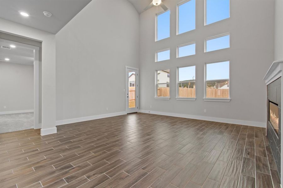 Unfurnished living room with ceiling fan and a high ceiling