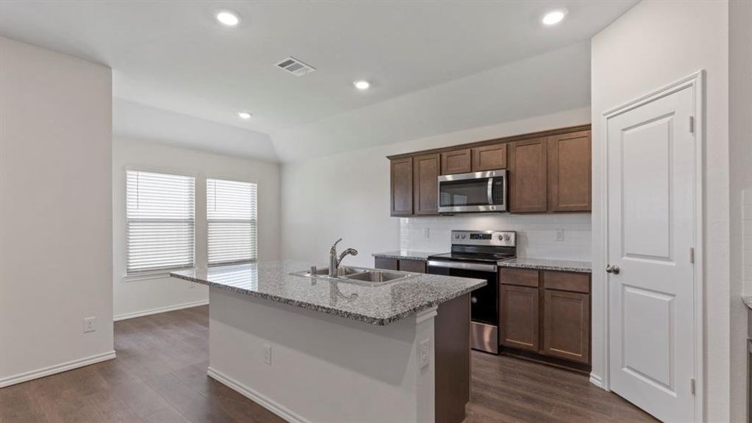 Kitchen island with a double basin sink and a granite-style countertop