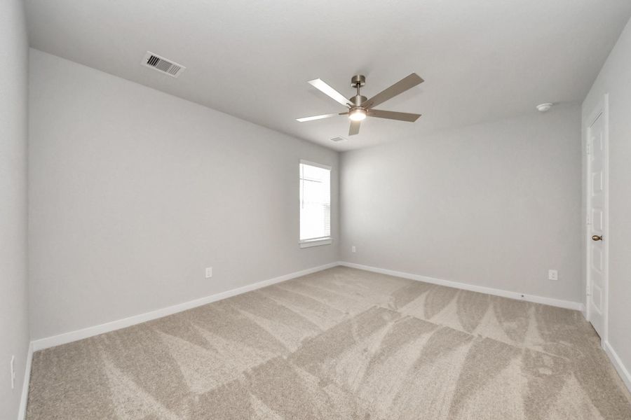 Secondary bedroom features plush carpeting, large windows that let in plenty of natural light, bright paint, and spacious closets.