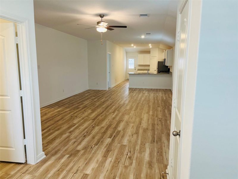 Unfurnished living room with light wood-style flooring and a ceiling fan