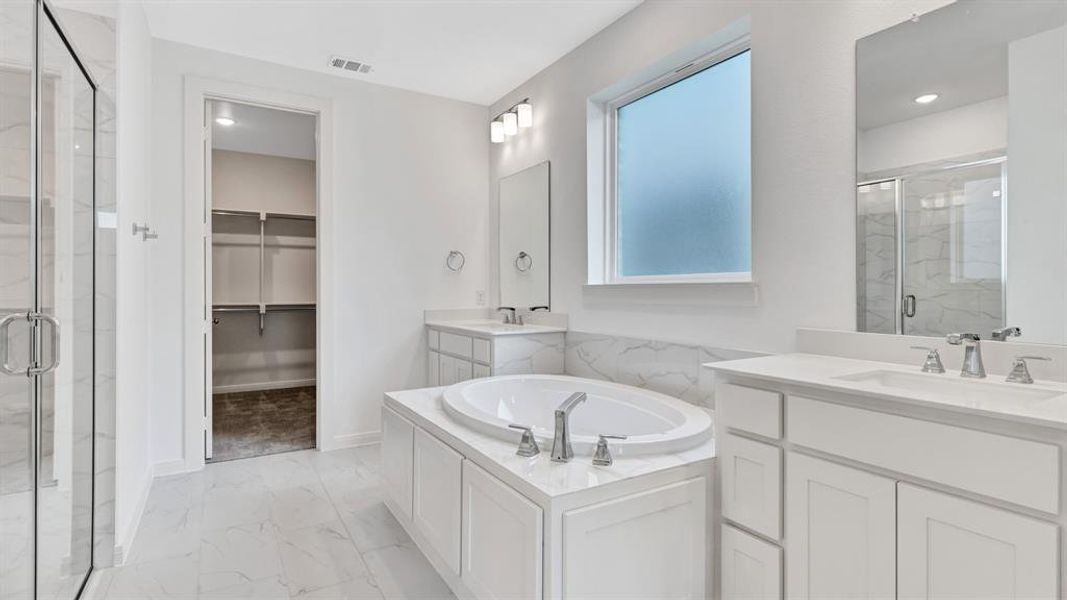 Bathroom featuring independent shower and bath, tile patterned floors, dual bowl vanity, and plenty of natural light