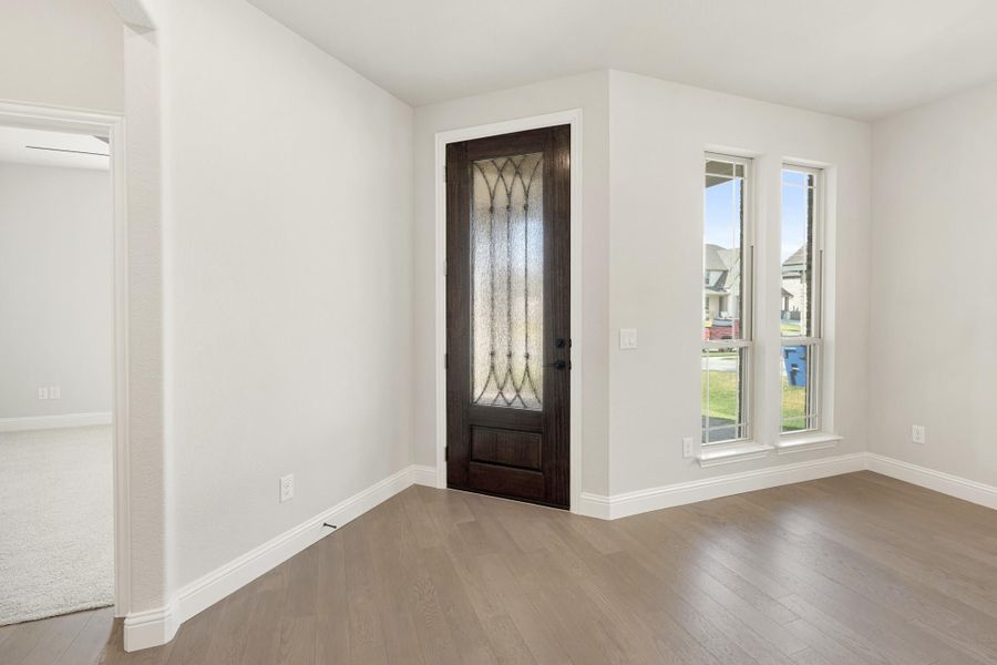 Entryway with dark wood front door featuring decorative glass panel and light hardwood floors